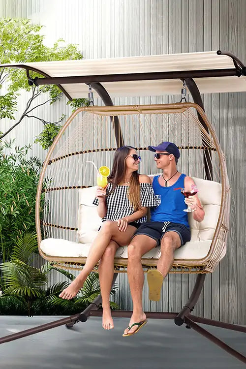 a man and a woman sitting on a swing chair.